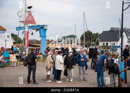 Schaprode, Deutschland. Juni 2021. Tagesausflügler stehen im Hafen von Neuendorf auf der kleinen Ostseeinsel Hiddensee, die wie ein Wellenbrecher die Westküste Rügens schützt. Die Einheimischen nennen Hiddensee auch liebevoll 'Dat söte Länneken'. Quelle: Stephan Schulz/dpa-Zentralbild/ZB/dpa/Alamy Live News Stockfoto