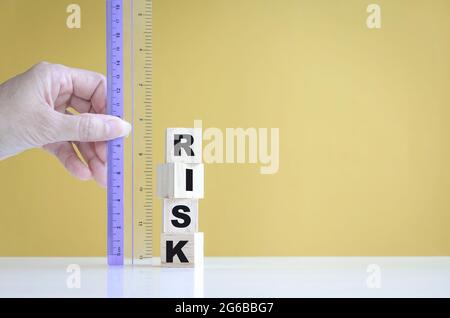 Die Hand der Geschäftsfrau misst das Risiko mit einem Lineal. Nahaufnahme. Geschäfts- oder Investitionskonzept. Stockfoto