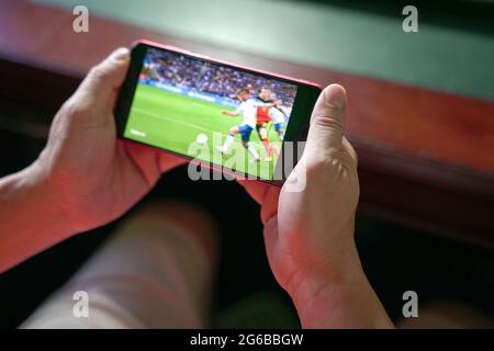 Mann, der Fußball und Sport auf dem Handy streamt. Nahaufnahme. Home Entertainment-Konzept. Stockfoto