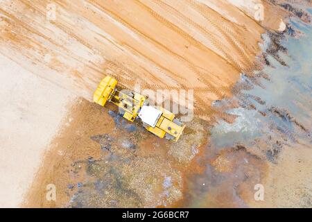 Luftaufnahme des arbeitenden Erdbewegers Gleiter flacht die Oberfläche ab Stockfoto