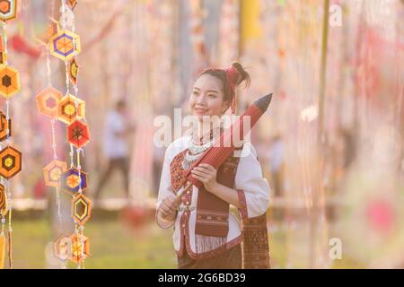 Porträt einer lächelnden Frau in traditioneller thailändischer Kleidung mit Sonnenschirm, Thailand Stockfoto