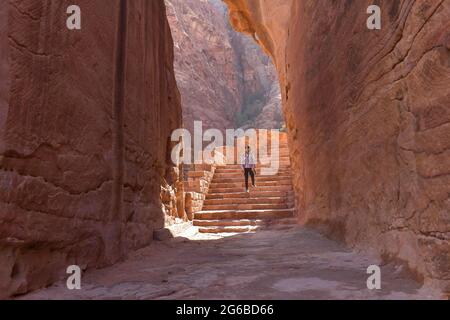 Rückansicht einer Frau, die in der alten Stadt Petra, Jordanien, eine Treppe hoch geht Stockfoto