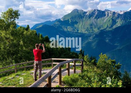 Ein Tourist bewundert die Landschaft der Julischen Alpen in Slowenien und macht Fotos Stockfoto