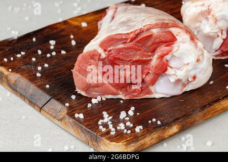 Rohe Lammschenkel auf Holzbrett aus nächster Nähe Stockfoto