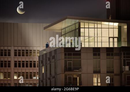 Ein Paar, das auf einer Dachterrasse steht und nachts tanzt, Los Angeles, Kalifornien, USA Stockfoto