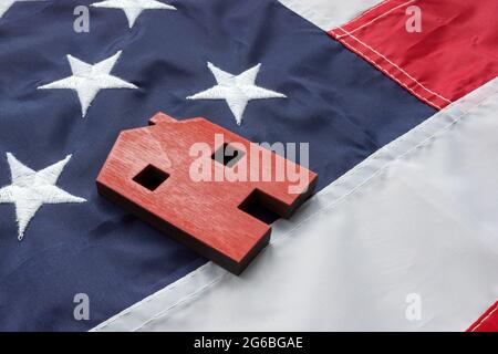 VA Rationalisierung der Refinanzierung für Darlehen zu Hause Konzept. Ein kleines Haus liegt auf der amerikanischen Flagge. Stockfoto