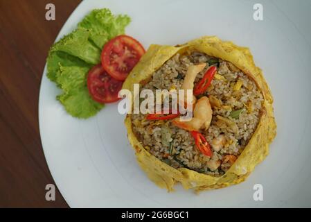 Der Nasi Pattaya ist ein südostasiatisches Gericht mit gebratenem Reis, das aus gebratenem Hühnerreis in dünnes Ei oder Omelette hergestellt wird. Stockfoto