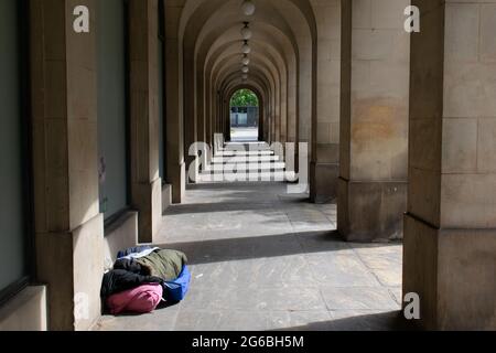 Obdachlose im Schlafsack unter den Bögen der Manchester Town Hall Extension Stockfoto