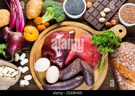 Sammeln Sie eisenreiche Lebensmittel wie Leber, Rindfleisch, Blutwurst, Eier, Roggenbrot, Dunkle Schokolade, Petersilienblätter, getrocknete Aprikosen, Bohnen, blauer Mohn, broc Stockfoto