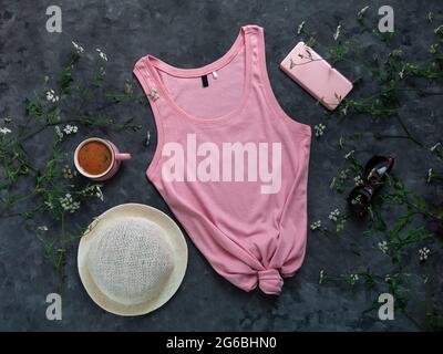 Tanktop aus rosa Baumwolle auf dunklem Hintergrund. Leere einfarbige T-Shirt-Vorlage für kreatives Design. Weibliche Sommer Sonnenbrillen Kleidung Mode ärmellos Stockfoto