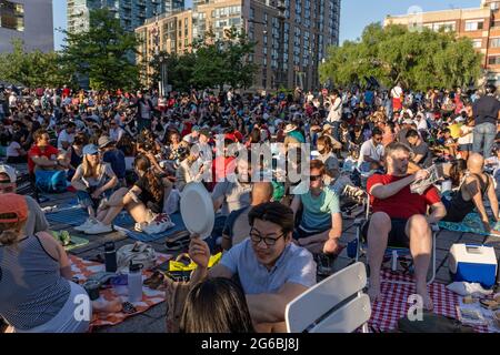 NEW YORK, NY - 04. JULI 2021: Die Zuschauer warten auf die 45. Jährliche Macy's Feuerwerke am 4. Juli mit Blick auf die Skyline von Manhattan am Gantry State Plaza in Long Island City im Stadtteil Queens von New York City. Die diesjährige Feier sollte größer und länger sein und 25 Minuten dauern als in den Vorjahren. Kredit: Ron Adar/Alamy Live Nachrichten Stockfoto