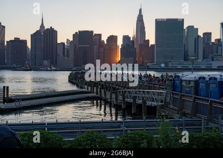 NEW YORK, NY - 04. JULI 2021: Die Zuschauer warten auf die 45. Jährliche Macy's Feuerwerke am 4. Juli mit Blick auf die Skyline von Manhattan am Gantry State Plaza in Long Island City im Stadtteil Queens von New York City. Die diesjährige Feier sollte größer und länger sein und 25 Minuten dauern als in den Vorjahren. Kredit: Ron Adar/Alamy Live Nachrichten Stockfoto