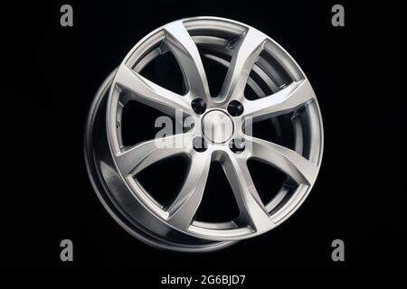 Leichtmetallfelge aus nächster Nähe. Silberne Metallic-Farbe auf schwarzem Hintergrund Stockfoto