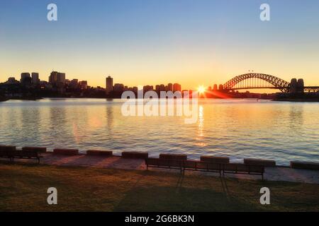 Kontrastieren Sie die Skyline der Wahrzeichen Sydneys bei Sonnenaufgang über dem Hafen von North Sydney Shore bis CBD. Stockfoto