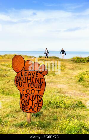 Anti-Verschmutzung-Schild in Form eines Fußes, auf dem Zufahrtsweg zum öffentlichen Strand von Troon, Ayrshire, Schottland, Großbritannien Stockfoto