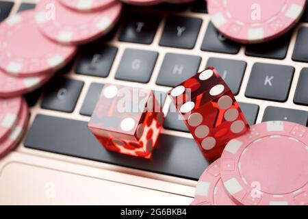 Casino Chips und Würfel Stapeln auf einem Laptop. Stockfoto