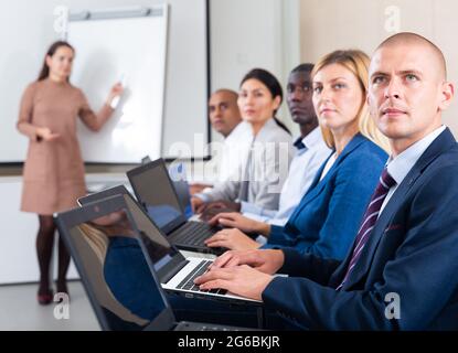 Seitenansicht der Manager-Gruppe, die an Laptops im Büro arbeitet Stockfoto