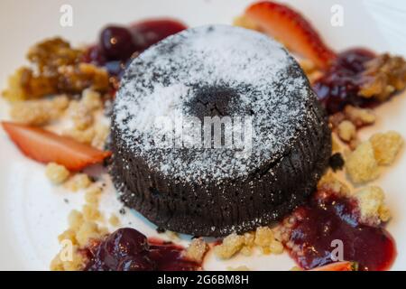 Schokoladenfondant Lavakuchen mit Erdbeeren auf weißem Teller servieren Stockfoto