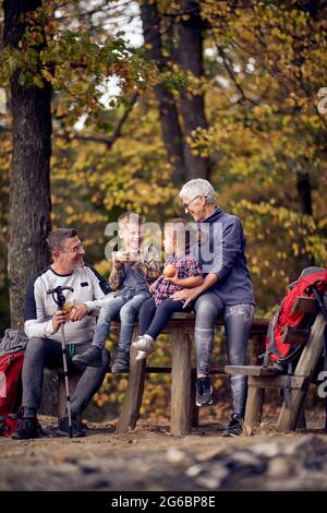 Großmutter, Großvater und Enkel genießen an einem schönen Herbsttag schöne Momente im Wald Stockfoto