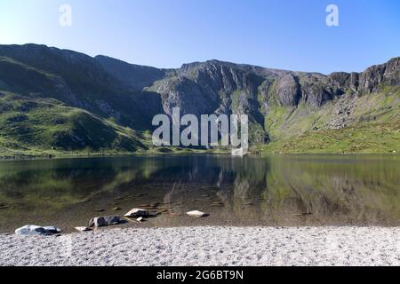 Die CWM Idwal Berge spiegeln sich an einem sonnigen Tag im Wasser von Llyn Idwal wider Stockfoto