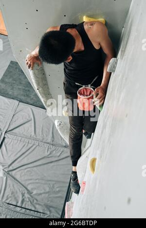 Fit junger Mann üben Klettern in Indoor-Kunstfelsen Boulderzentrum Stockfoto