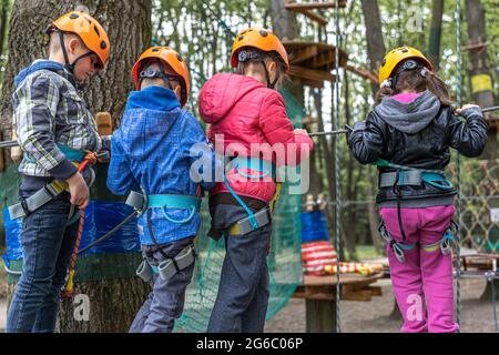 Kinder an den Seilen entwickeln Kletterfähigkeiten und beseitigen Höhenangst. Stockfoto