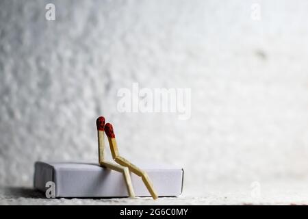 Zwei romantische Streichhölzer in Love Sitting Together. Liebe Und Romantik Konzept. Die Matchstick-Kunstfotografie verwendete Matchsticks, um den Charakter zu erschaffen. Stockfoto