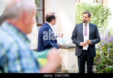 Hannover, Deutschland. Juli 2021. Jörn Ehlers (l.), Vizepräsident Landvolk Niedersachsen, übergibt die Ergebnisse einer repräsentativen Umfrage zu Wölfen an Olaf Lies (SPD), den niedersächsischen Umweltminister. Das Landvolk Niedersachsen hat eine repräsentative Umfrage zum Schutz von Weidevieh und Wölfen in Niedersachsen durchgeführt. Quelle: Hauke-Christian Dittrich/dpa/Alamy Live News Stockfoto