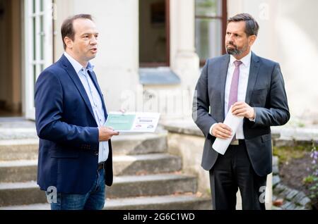 Hannover, Deutschland. Juli 2021. Jörn Ehlers (l.), Vizepräsident Landvolk Niedersachsen, übergibt die Ergebnisse einer repräsentativen Umfrage zu Wölfen an Olaf Lies (SPD), den niedersächsischen Umweltminister. Das Landvolk Niedersachsen hat eine repräsentative Umfrage zum Schutz von Weidevieh und Wölfen in Niedersachsen durchgeführt. Quelle: Hauke-Christian Dittrich/dpa/Alamy Live News Stockfoto