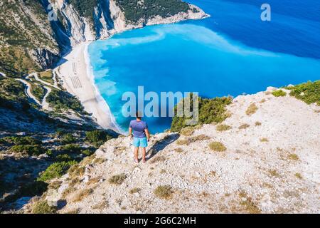 Ein Mann steht und genießt den Blick auf den wunderschönen Myrtos Strand in Kefalonia, Griechenland Stockfoto