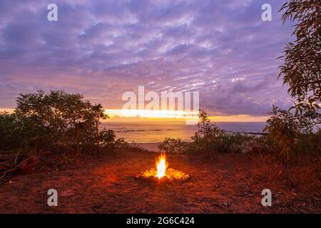 Lagerfeuer am Strand bei Sonnenaufgang über Pender Bay Escape, Dampier Halbinsel, Westaustralien, WA, Australien Stockfoto