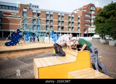 Hannover, Deutschland. Juli 2021. Mitarbeiter der Stadt Hannover Pflanzen die Blumenbeete eines temporären Sitzbereichs auf der teilweise geschlossenen Schmiedestraße in der Innenstadt. Die Stadt schließt in den kommenden Wochen mehrere Straßen im Stadtzentrum für den Autoverkehr. Sie sollen zu temporären Fußgängerzonen werden. Quelle: Hauke-Christian Dittrich/dpa/Alamy Live News Stockfoto