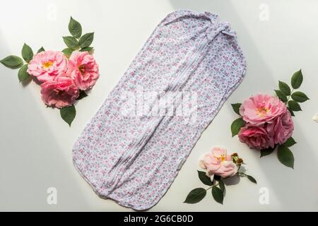 Neugeborener Strampler mit Blumenmuster und Rosenzusammensetzung. Isoliert auf weißem Hintergrund Stockfoto