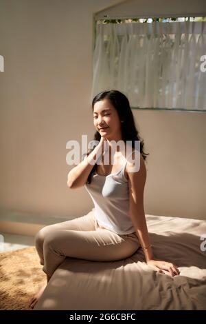 Junge Frau Anwendung Creme für den Körper zu Hause Stockfoto