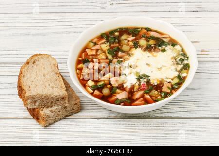 Der Teller mit der russischen Okroschka mit kwass close-up auf dem hölzernen Tisch Stockfoto