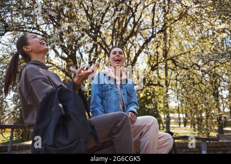 Zwei Frauen lachen über Witz im Park Stockfoto