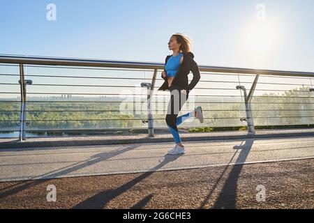 Motivierte Frau, die unter freiem Himmel läuft Stockfoto