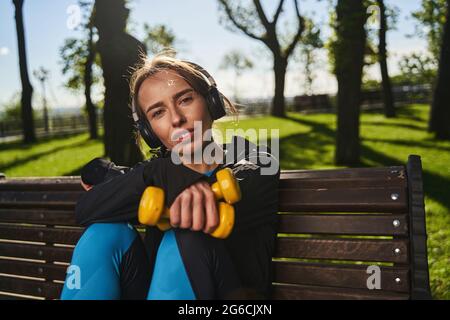 Ruhige, hübsche Frau, die sich nach dem Training im Park entspannt Stockfoto