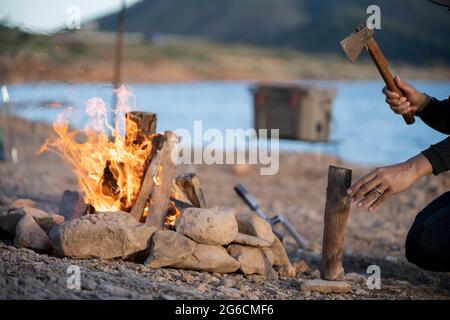 Erwachsene Mann hackt Zweige mit Axt für Lagerfeuer. Stockfoto