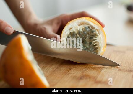 Frische, reife Bio-Granadilla oder gelbe Passionsfrucht, halbiert auf einem Holzbrett. Exotische Früchte, gesunde Ernährung Konzept Stockfoto