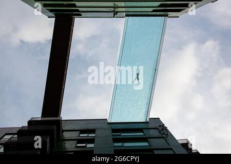 Die 35 Meter hohe transparente Sky Pool Bridge zwischen zwei Gebäuden in den Embassy Gardens ist Londons exklusivster Außenpool. London, Großbritannien. Stockfoto