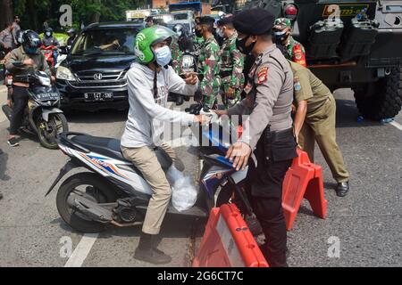 South Jakarta, Indonesien. Juli 2021. Die gemeinsame indonesische Polizei und Militärmacht halten Motorräder und Autos an der Kontrollstelle in Jakarta an. Indonesien hat ab Juli 3-20 in Java und Bali Einschränkungen für die Aktivitäten der Gemeinschaft in Notfällen, lokal bekannt als PPKM, verhängt, um den Ausbruch von Covid-19 einzudämmen, nachdem sich die vorherige Politik von Micro PPKM als unwirksam erwiesen hatte. Kredit: SOPA Images Limited/Alamy Live Nachrichten Stockfoto