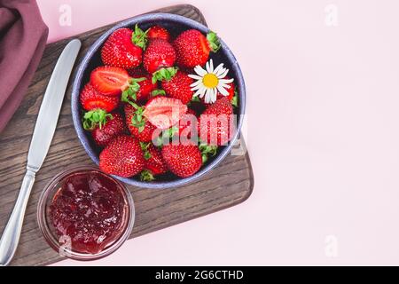 Hausgemachte Erdbeermarmelade oder Erdbeergelee mit frisch reifen Erdbeeren auf einem weißen Teller. Frühstück mit Brot Toast mit Erdbeermarmelade. Messer für s Stockfoto