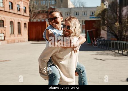 Waist-up-Porträt eines sorglosen jungen Paares, das Spaß in der Sommerstadt hat Stockfoto