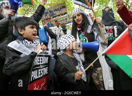 London, Großbritannien. Mai 2021. Kinder singen Parolen, während sie während der Demonstration ein Plakat und eine Fahne in der Hand halten.Tausende pro-palästinensische Demonstranten versammeln sich am Ufer, bevor sie durch das Zentrum Londons zum Hyde Park marschieren. Sie fordern ein Ende der israelischen Politik der Diskriminierung von Palästinensern, ein freies Palästina und ein Ende der illegalen Besetzung des Gazastreifens. Quelle: Martin Pope/SOPA Images/ZUMA Wire/Alamy Live News Stockfoto