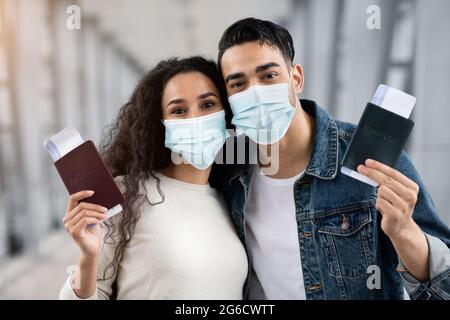 Junges Arabisches Paar Mit Medizinischen Masken In Flughafen Holding Pässe Und Tickets Stockfoto