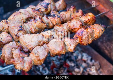 shish Kebab im Freien auf dem Grill. Kochen Fleisch auf der Straße. Street Food. Picknick. Familie Ruhe. Hitze von Kohlen auf dem Grill. Shish Kebab von Stockfoto