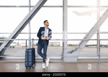 Handsome Arab Man Holding Pässe Und Tickets Stehen Mit Koffer Im Flughafen Stockfoto
