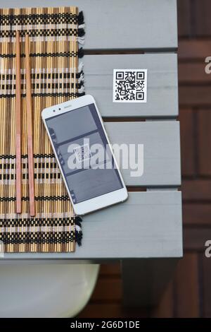 Von oben des Mobiltelefons auf dem Tisch mit QR-Code des Restaurants Menü platziert Stockfoto