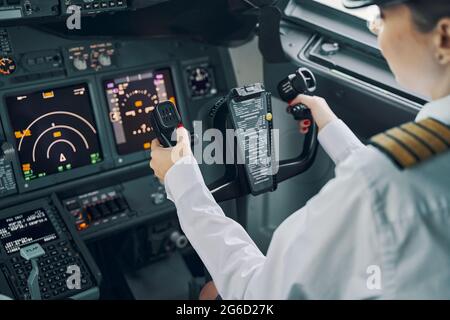 Eine professionelle Pilotin navigiert in einem Flugzeug Stockfoto